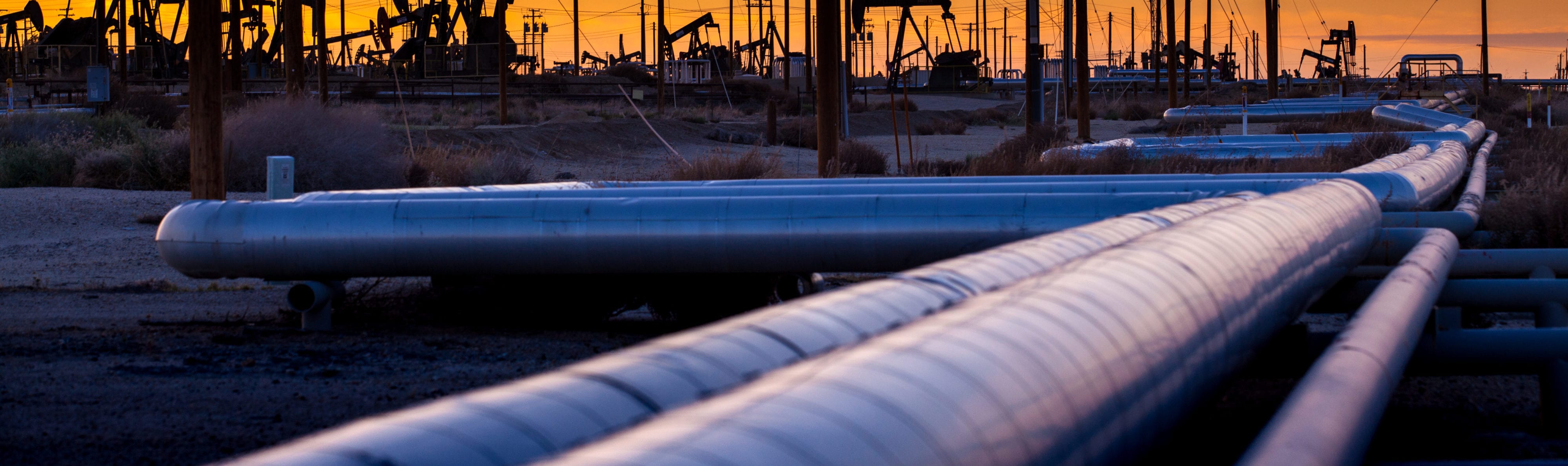 Oil field pipeline at sunset